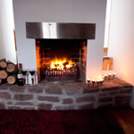 Stone hearth and open fire at Achill Cottages